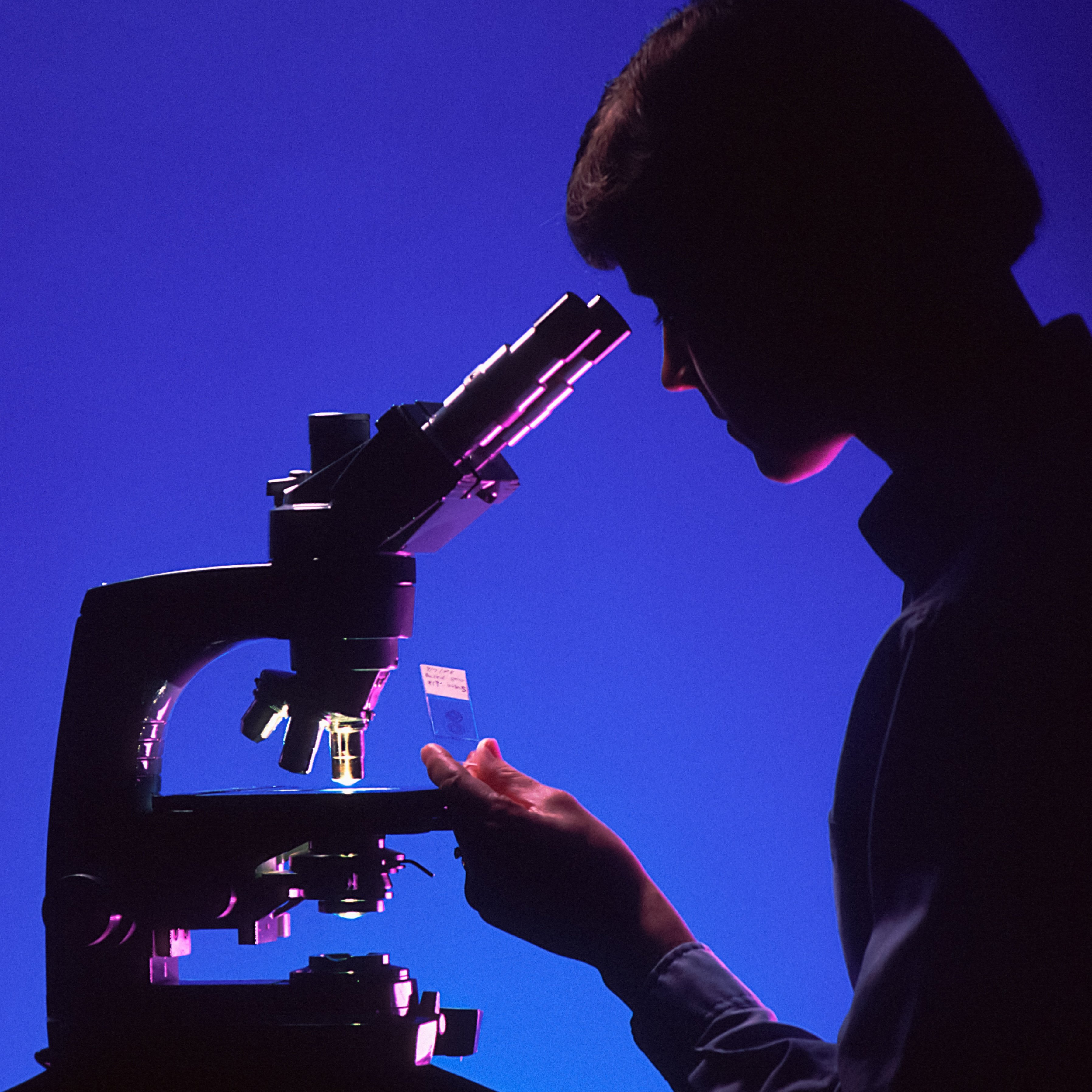 Woman working with a microscope.