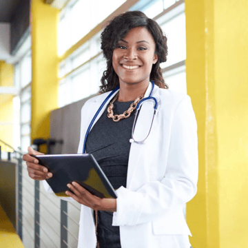 a woman doctor holding a tablet and smiling